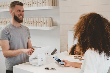 ragazza paga con smartphone contactless