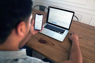 Uomo controlla conto corrente online da PC e smartphone